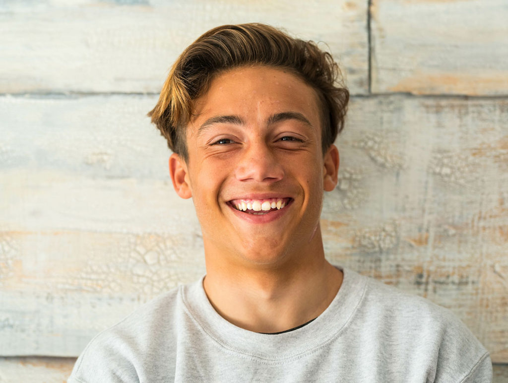 male teenager smiling big with straight teeth