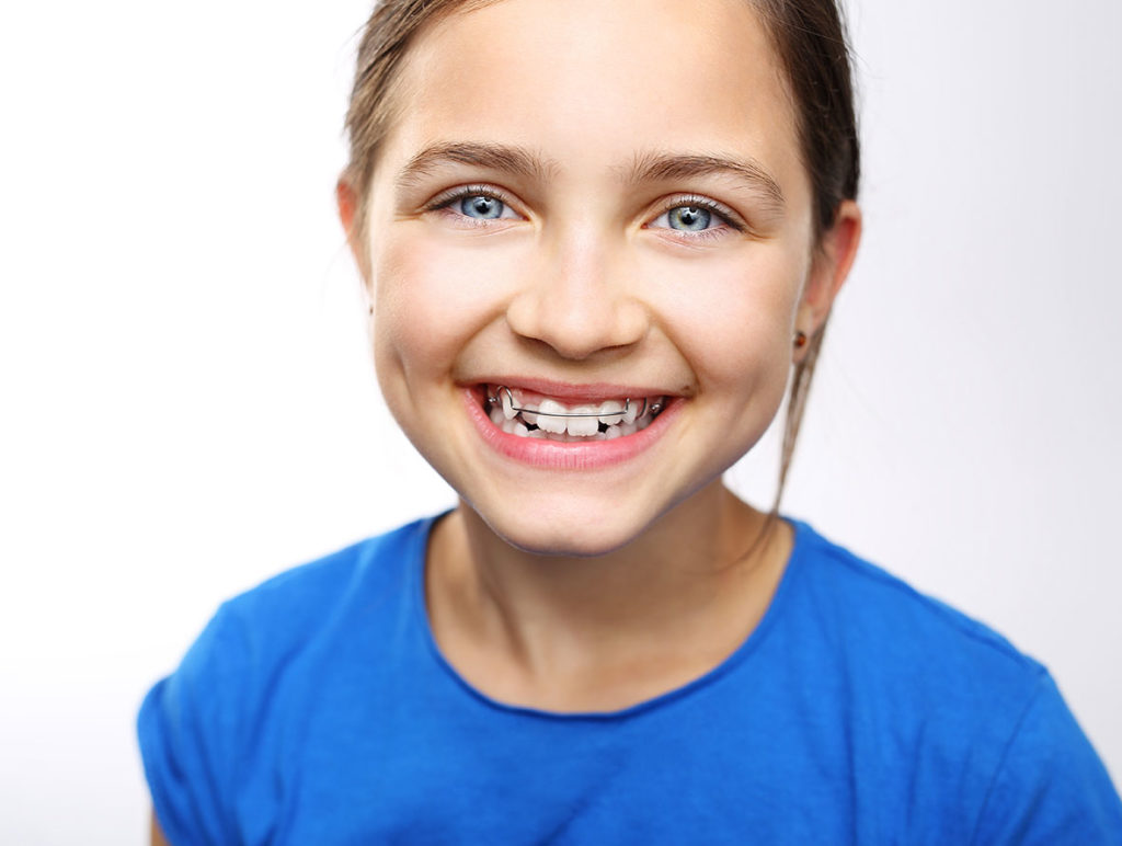 young girl wearing an orthodontic retainer to help straighten her teeth peoria il